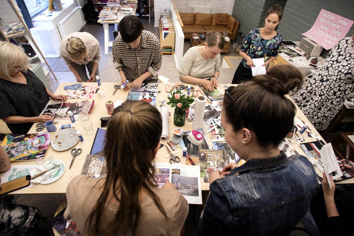 Ensin pöydän ääressä pulistaan, sitten keskitytään. Collage Clubin työpajassa Riitta Skytt (vas.), Jenni Ylinen, Loi Oleinik ja Leena Holmila leikkaavat, sommittelevat ja liimaavat.