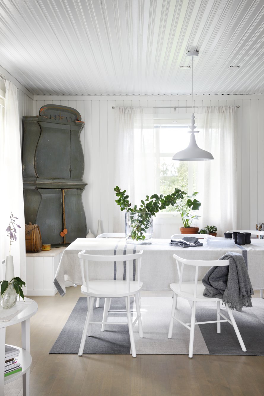 Vanhan perintökaapin väritys toi saven sävyt alakertaan. Artekin ruokapöytä on palvellut pitkään. Sen ilme uudistuu moderneilla pellavaliinoilla. Woodnotesin matto on valmistettu Lapualla, ja oli siksi itsestäänselvä hankinta.