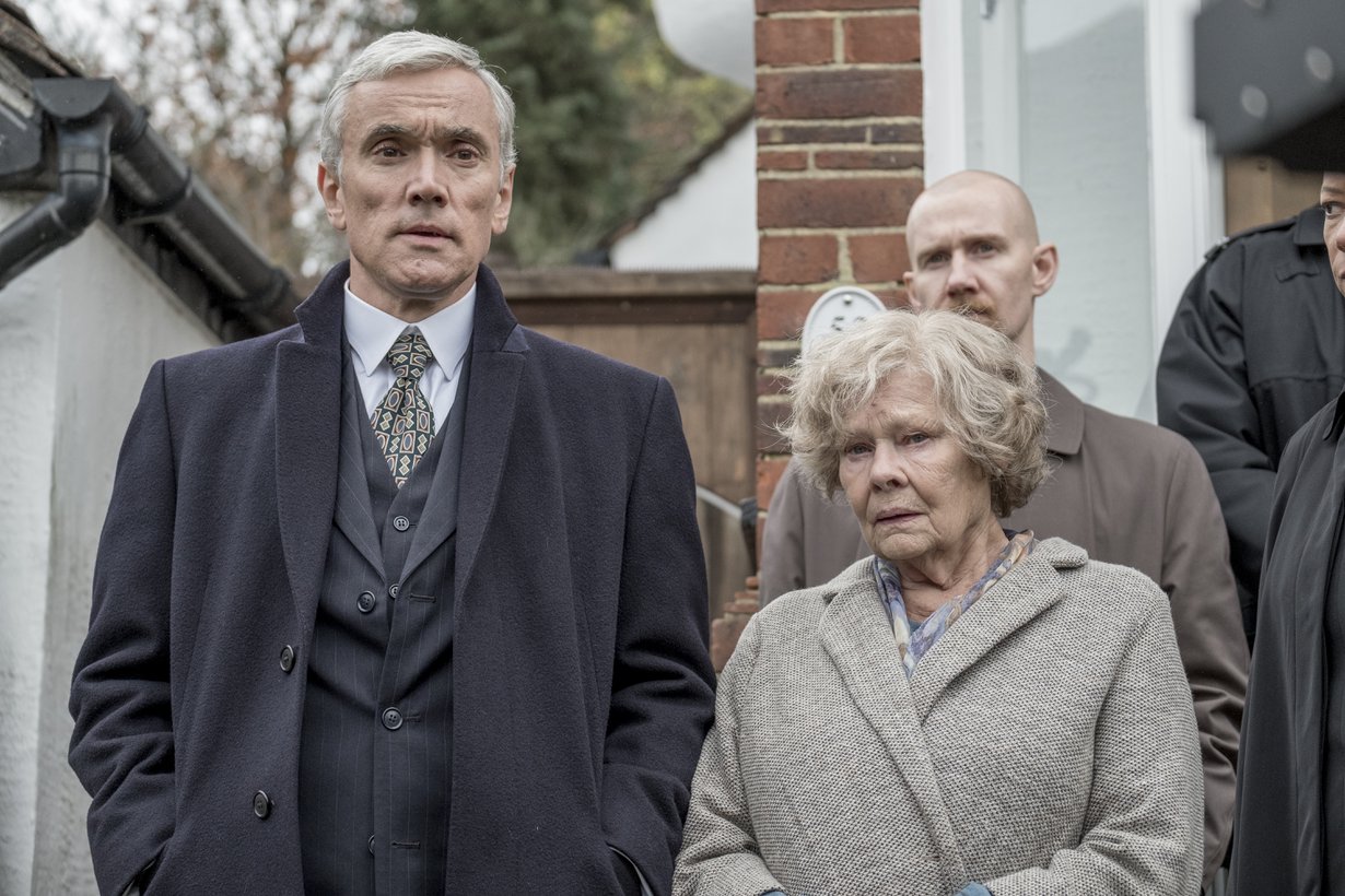 Iso-Britannian salaisen palvelun agentit kolkuttavat kirjastonhoitaja Joan Stanleyn ( Judi Dench) ovelle ja pidättävät eläkeläisnaisen syytettynä maanpetoksesta. Kuva: Finnkino