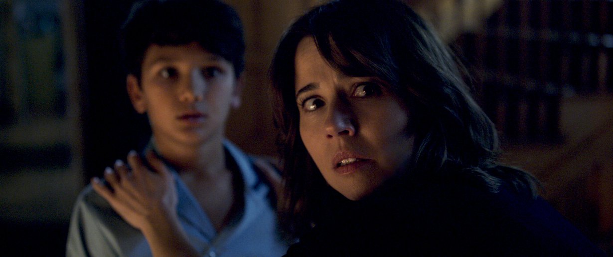 Haamu alkaa vainota yksinhuoltaja Annaa (Linda Cardellini) ja hänen kahta lastaan 1970-luvulla. Kuva: Warner Bros.