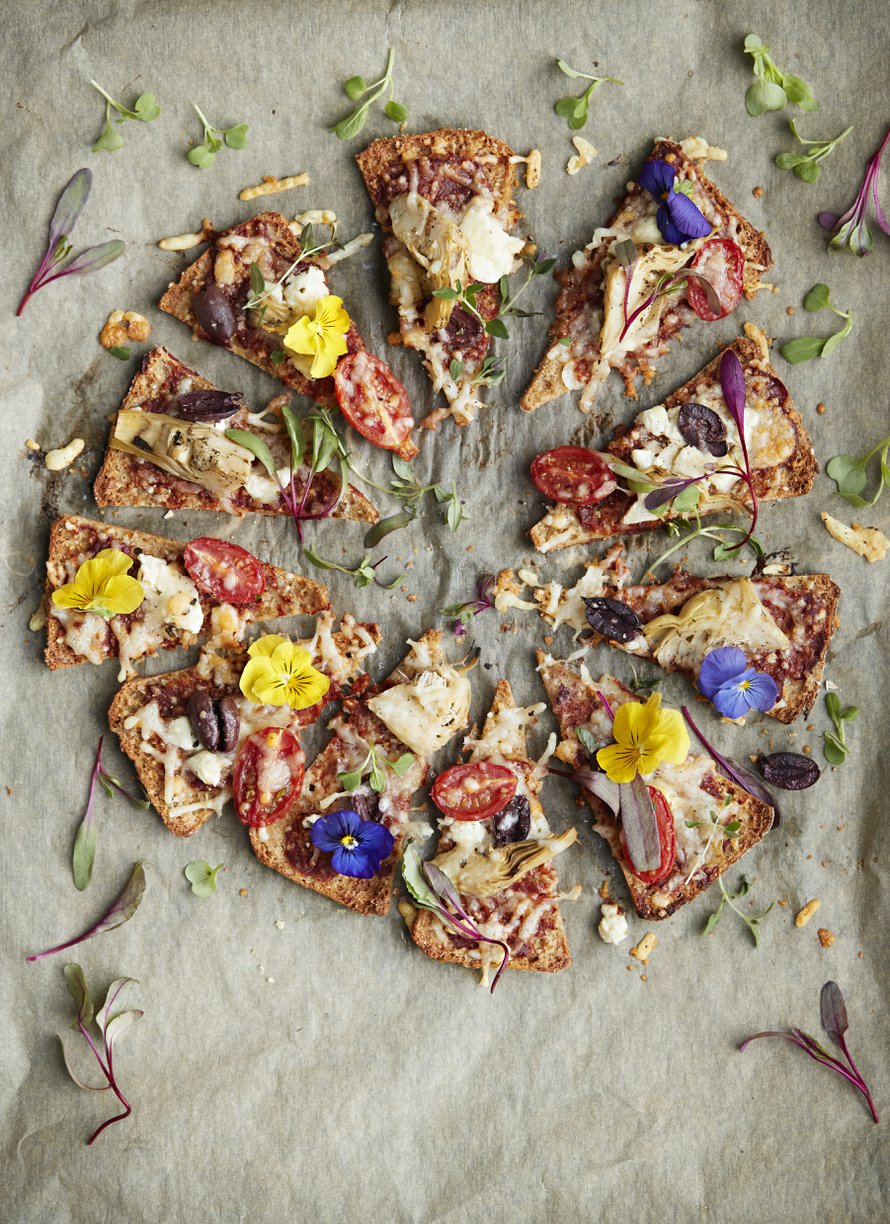 Hifistelijä koristelee lämppäripizzan syötävillä kukilla. Kaunista arkea!